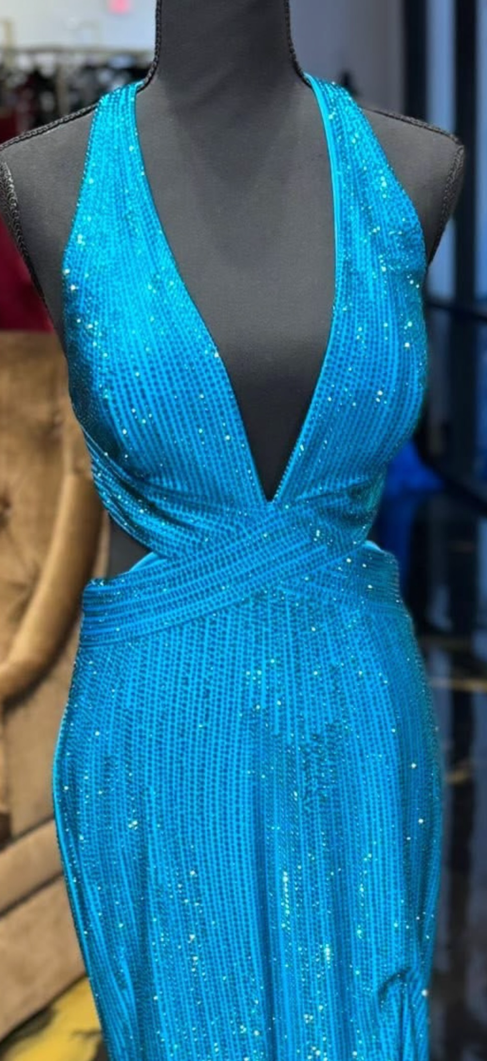 Blue beaded dress on a mannequin against a blurred indoor background